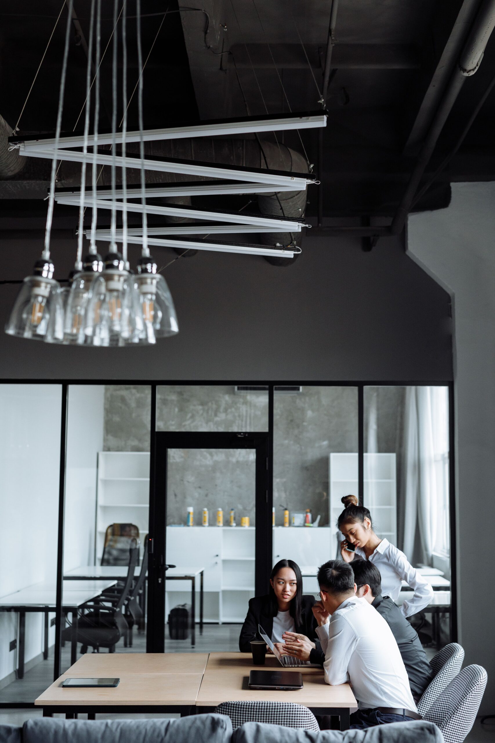 Business professionals engaged in a collaborative meeting in a stylish, modern office setting.